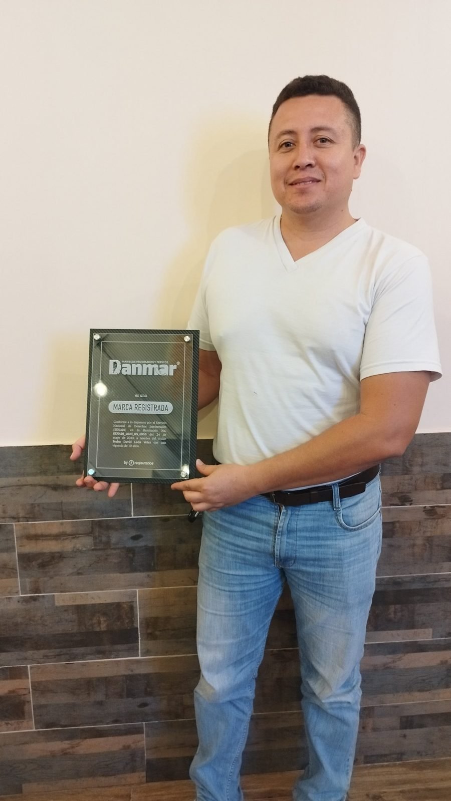 Pedro León sostiene la placa de acrílico de Danmar con la leyenda Marca Registrada