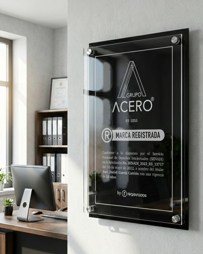 Placa de acrílico negra de Grupo Acero con la leyenda Marca Registrada, montada en la pared de una oficina de arquitectura
